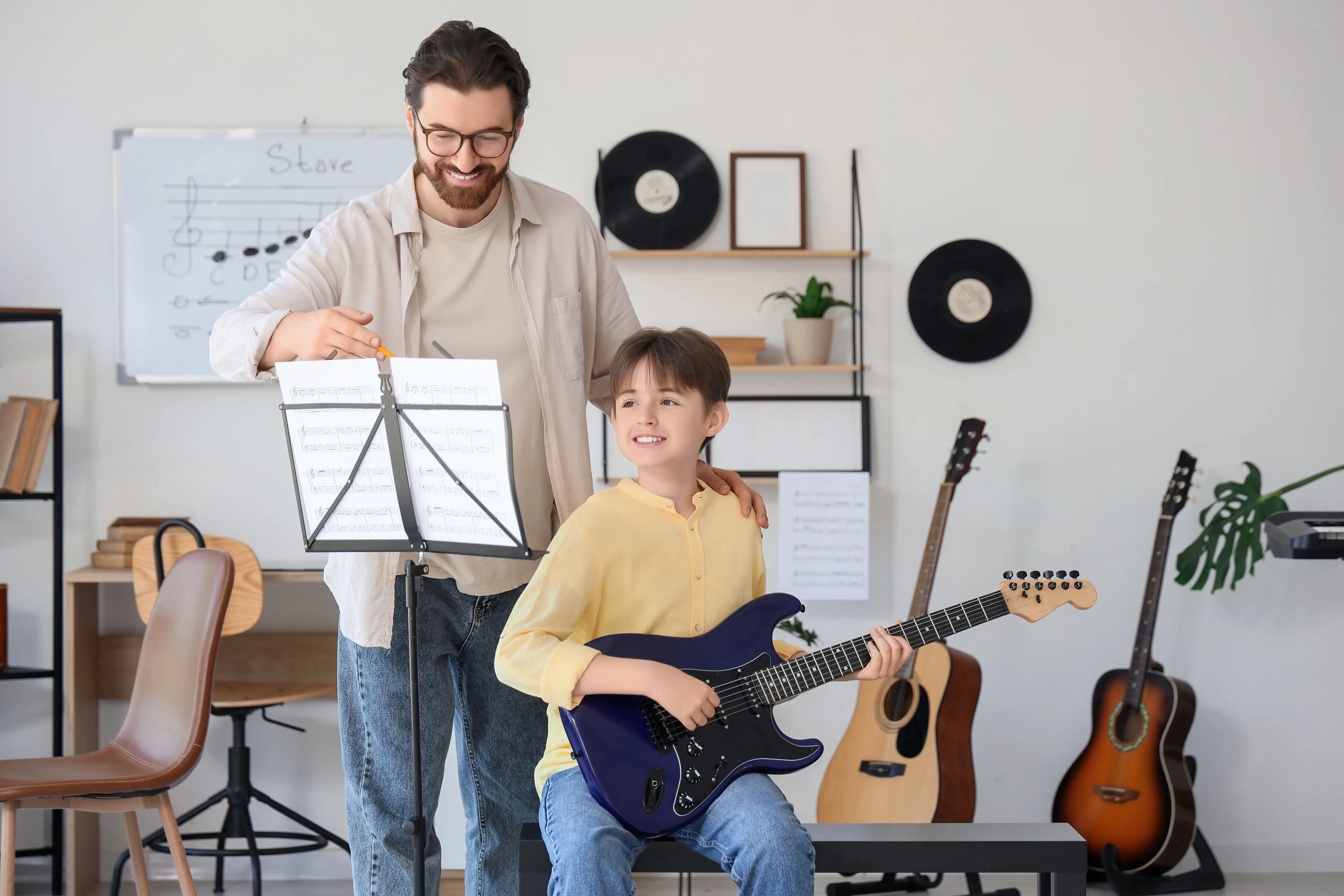 Teacher and student playing guitar